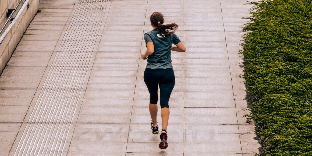 女性がランニングコースを走っている