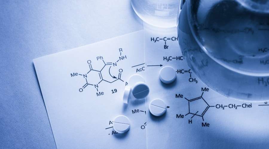 錠剤と化学記号が書かれた紙が置いてある。