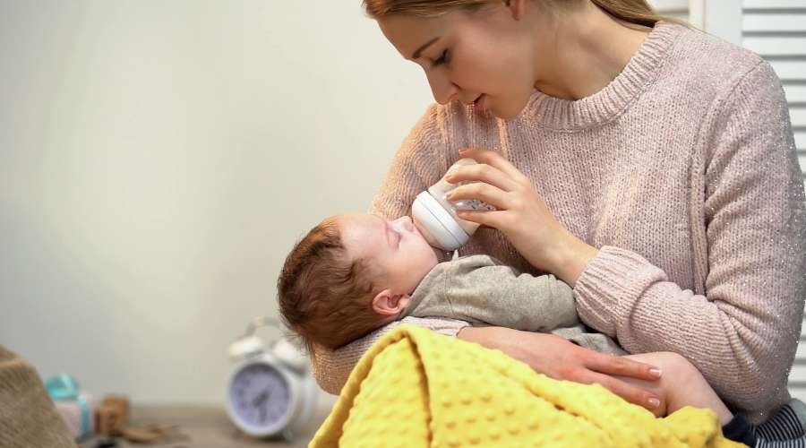 お母さんが赤ちゃんにミルクをあげている
